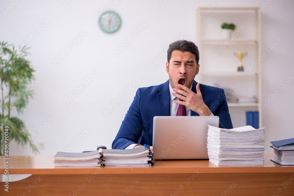 Young businessman and too much work in the office Young businessman and too much work in the office