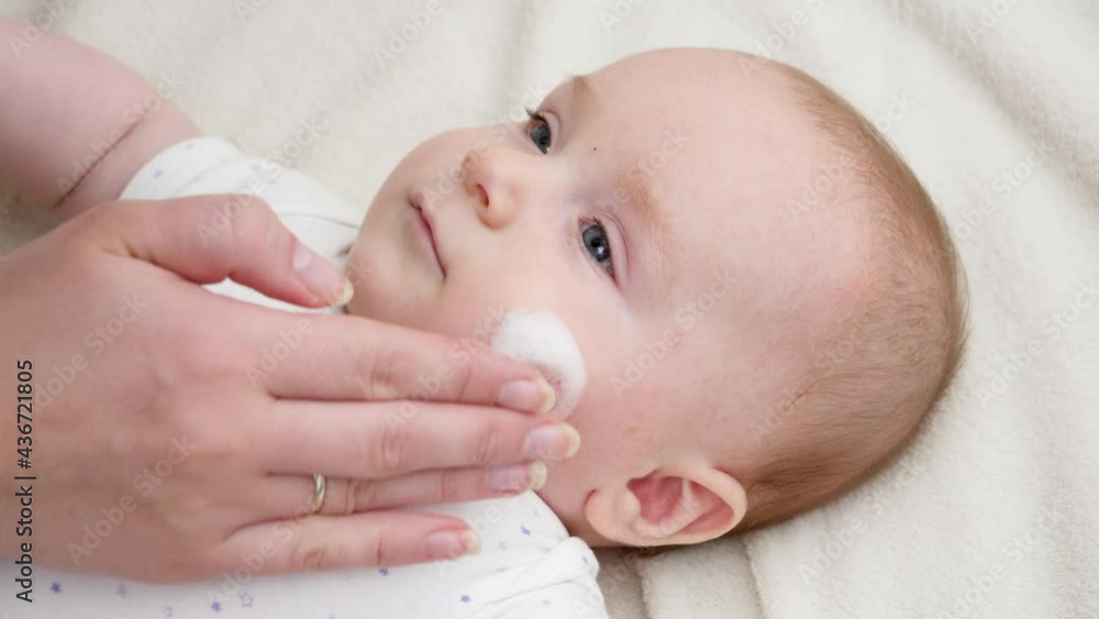 Mother using medical cream to cure problematic sking of her newborn baby. Concept of newborn baby hygiene, health and skin care Mother using medical cream to cure problematic sking of her newborn baby. Concept of newborn baby hygiene, health and skin care