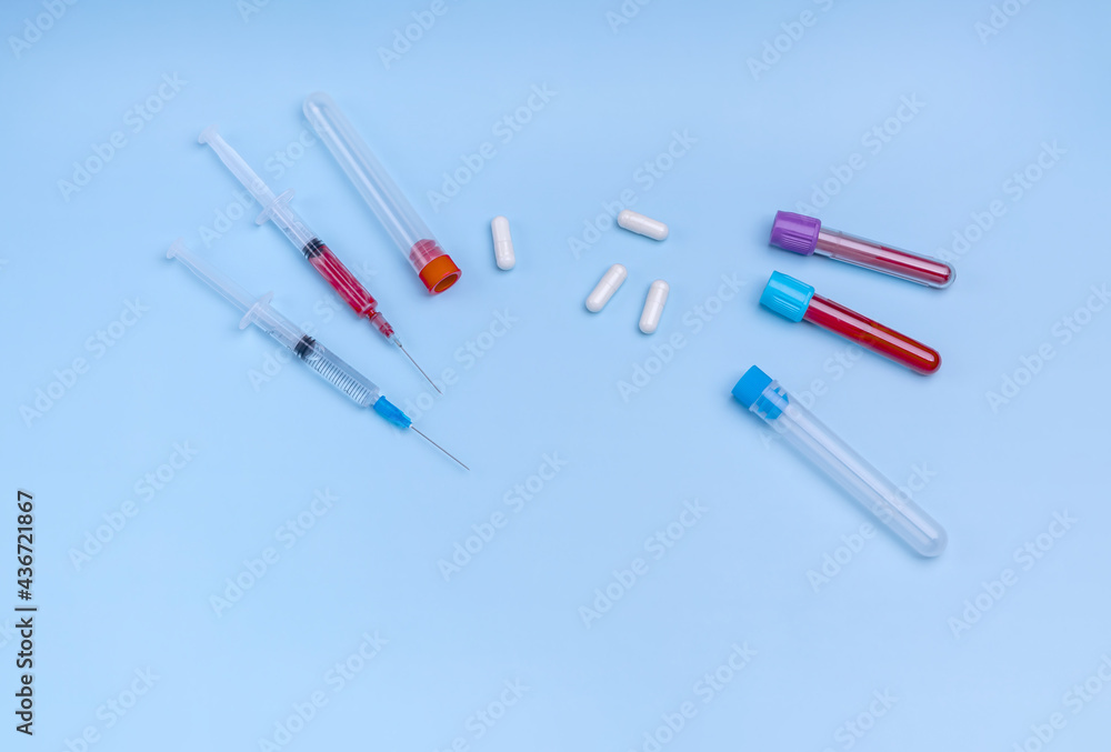 syringes, vials of blood, medical capsules on a blue background syringes, vials of blood, medical capsules on a blue background