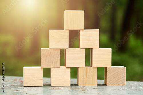 pyramid made from wooden toy blocks on nature background