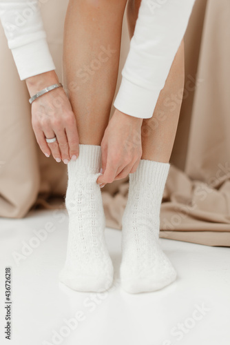 white knitted socks on female legs in the studio close-up