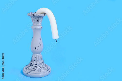 Candle Holder with a Drooping Candle on a Blue Background Concept Impotence Impotence and Old Age in Sex photo