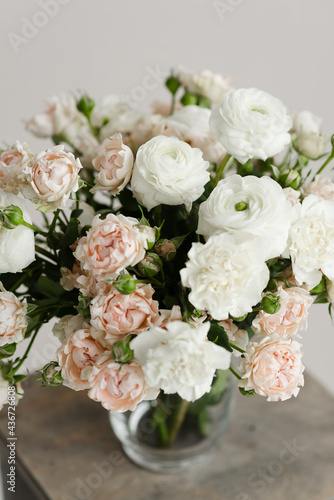 bouquet of flowers in a vase on a wooden table on a white solid background