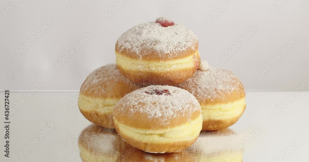 Donuts with stuffing sprinkled with white powdered sugar close up. Delicious sweet donut. Making donuts with jam. Donuts with stuffing sprinkled with white powdered sugar close up. Delicious sweet donut. Making donuts with jam.