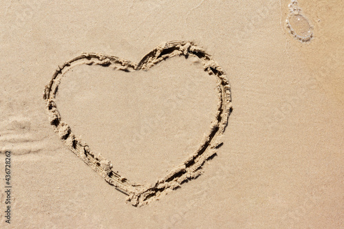 Heart drawn On Ocean Beach Sand. Heart shape drawn on the sandy beach. true love concept..