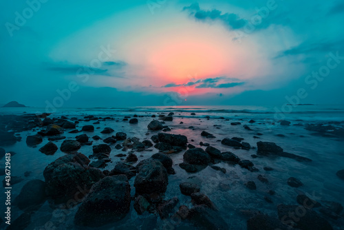 Beautiful Sun rise at the beach with rock around and sun clear visibel. Water waves at slow shutter speed. Morning sunrise photo