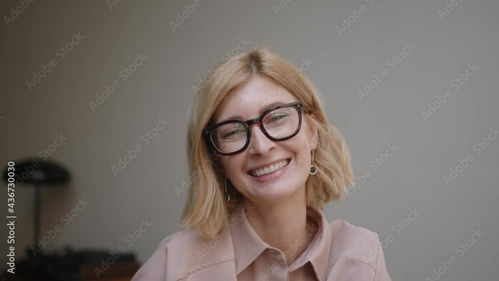 Blonde woman portrait in eyeglasses talking and smiling. Attractive stylish adult person looking at the camera with sincere and happy smile. Concept of good mood Blonde woman portrait in eyeglasses talking and smiling. Attractive stylish adult person looking at the camera with sincere and happy smile. Concept of good mood