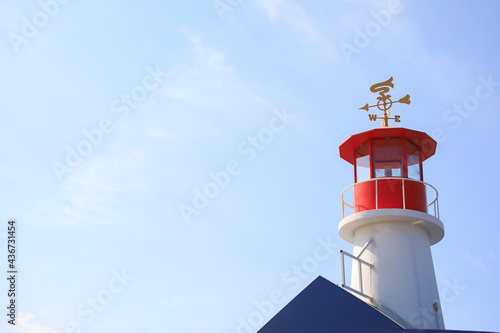 Red and white lighthouse with a blue sky in the summer