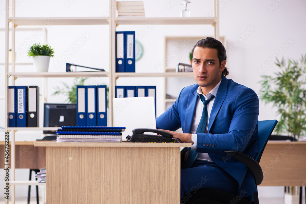Young handsome employee sitting in the office Young handsome employee sitting in the office