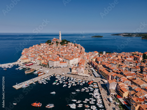 Top view of the old town of Rovinj, seaport, houses with red roofs and the sea, Croatia. The tiled roofs of the old city against the background of the bright blue sea and sky, on a sunny day photo