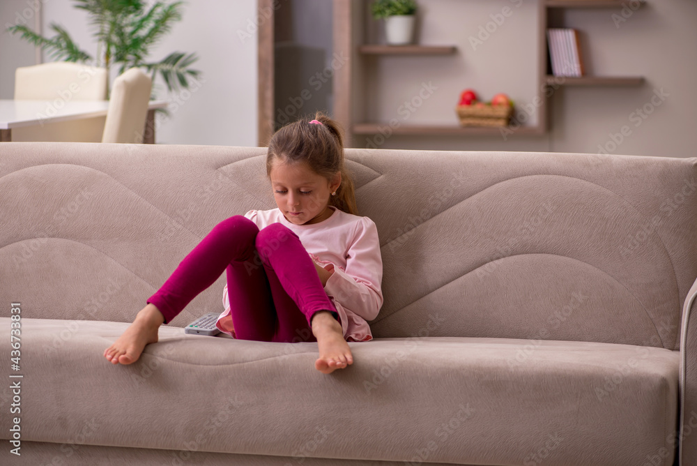 Small girl holding smartphone waiting for parents at home