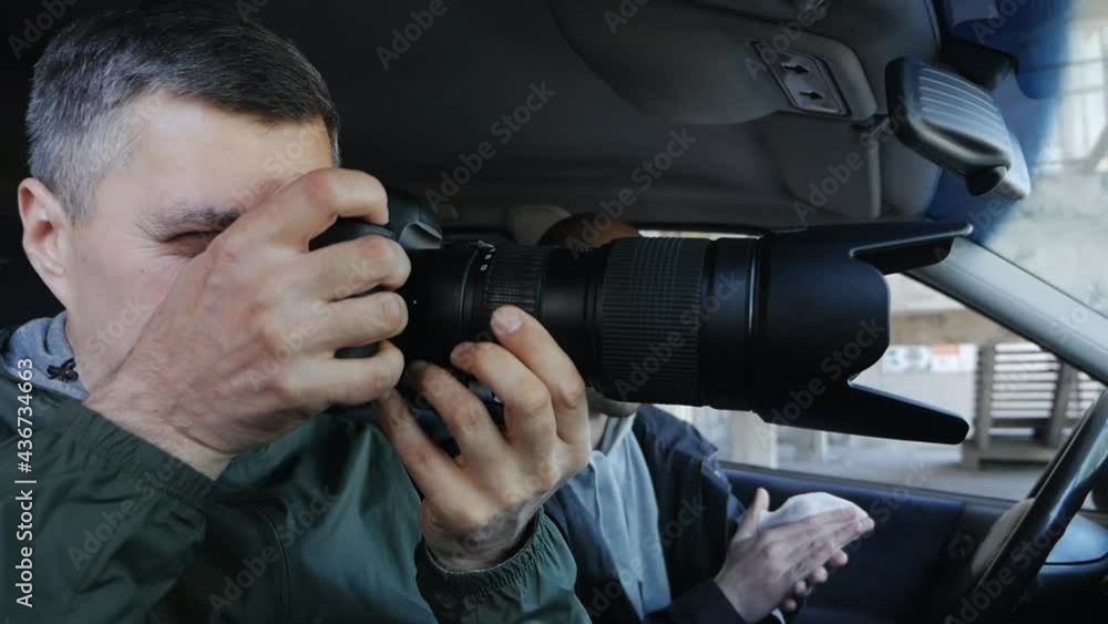 Paparazzi or detectives secretly photograph something while sitting in the car. Collecting compromising evidence or material for an article Paparazzi or detectives secretly photograph something while sitting in the car. Collecting compromising evidence or material for an article