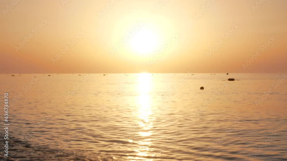 Natural sunrise sky warm colors over ripple sea. Bright sun on sea horizon Natural sunrise sky warm colors over ripple sea. Bright sun on sea horizon
