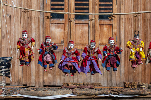 Colorful puppets in a tourist stall on the street market in Burma, Myanmar. Handmade dolls hanging on display store