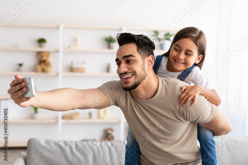 Handsome father taking selfie with cute daughter