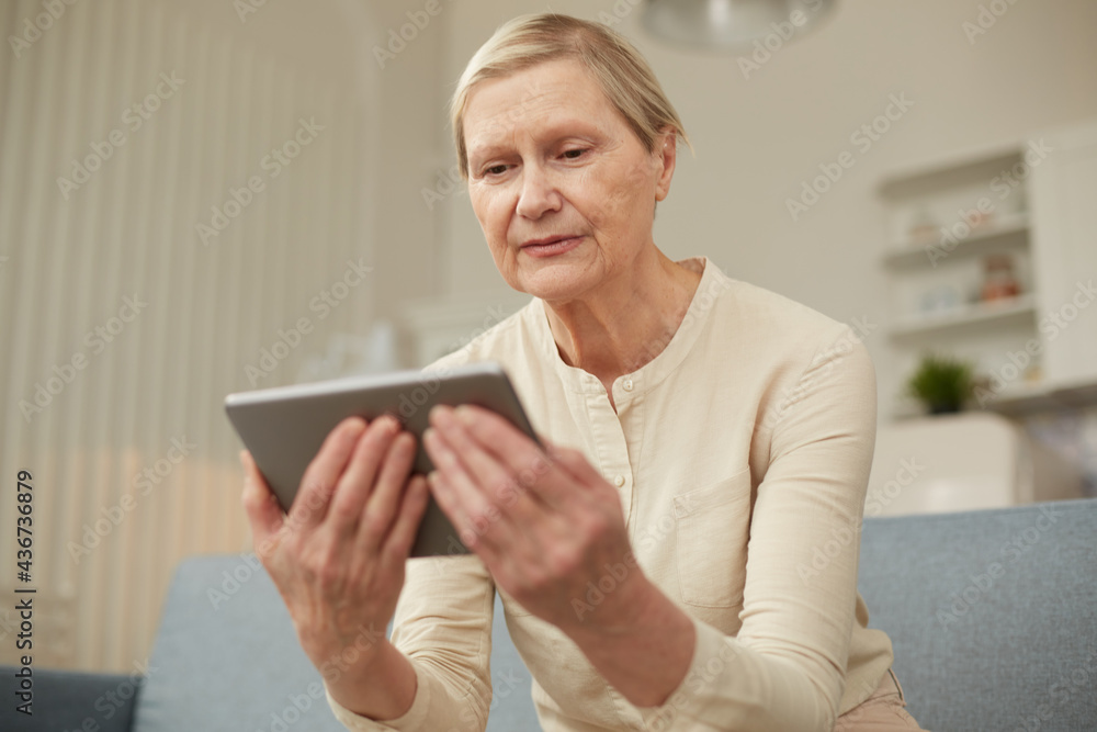 Senior woman using digital tablet at home. The use of technology by the elderly. Senior woman using digital tablet at home. The use of technology by the elderly.