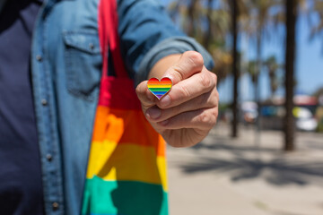 Man with rainbow reusable bag and lgbt badge, pride month