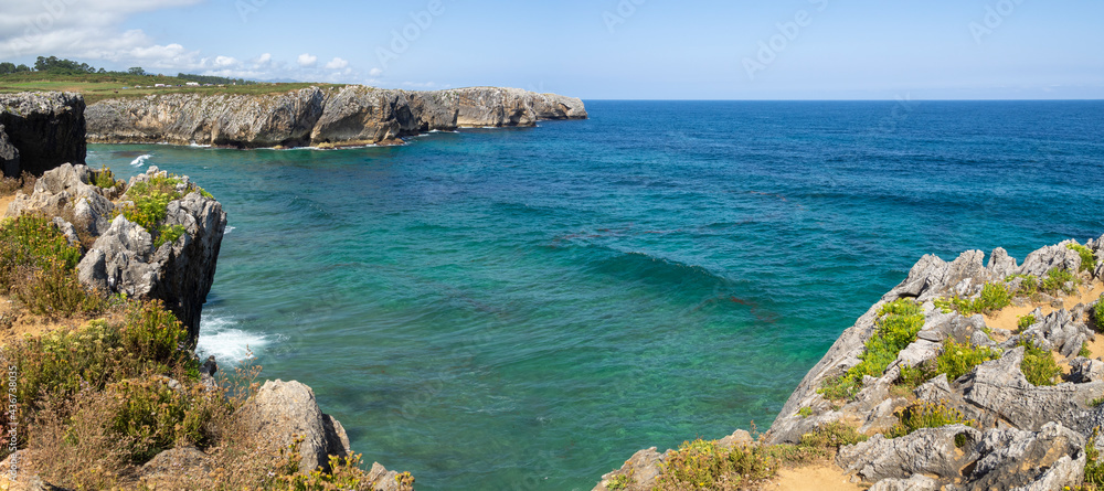 Paisaje panorámico de los Bufones de Pría en Asturias, España, verano de 2020. Con las vistas de los acantilados pedregosos y el mar con aguas azules y aguamarina.
