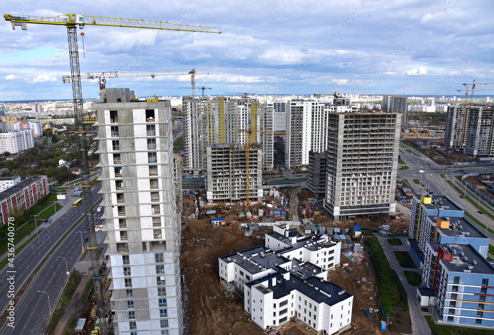 Fototapeta premium Tower crane during construction of a residential building. Cranes on formworks. Construction the building or multi-storey homes, Arial view. Renovation concept. Realtor and Real Estate