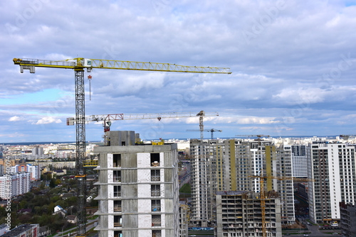 Tower crane during construction of a residential building. Cranes on formworks. Construction the building or multi-storey homes  Arial view. Renovation concept. Realtor and Real Estate