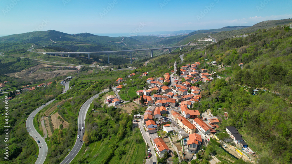 AERIAL Flying above a quiet town near a highway bridge crossing the green valley