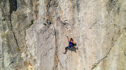 AERIAL: Drone view of a rock climber looking for a hold while learning to climb