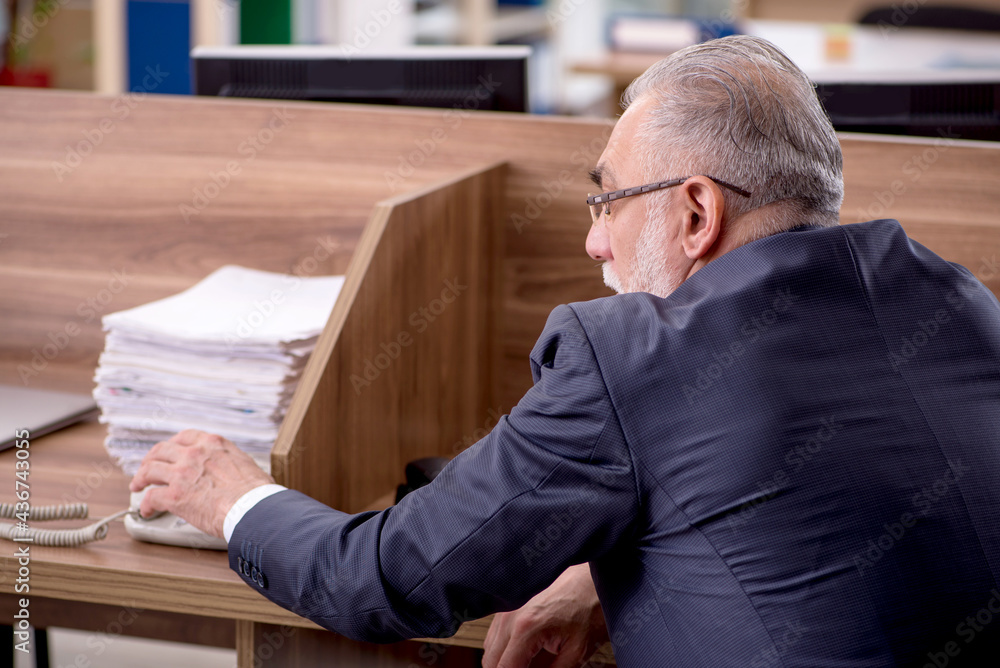 Fototapeta premium Old male employee sitting in the office