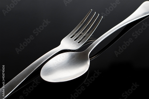 fork and spoon made of steel on black backround