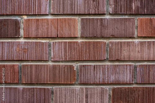 Wall of new building made with rows of rectangle red color bricks connected with concrete mix at bright light close view