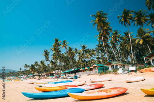 Canacona, Goa, India. Canoe Kayak For Rent Parked On Famous Palolem Beach On Background Tall Palm Tree In Summer Sunny Day photo