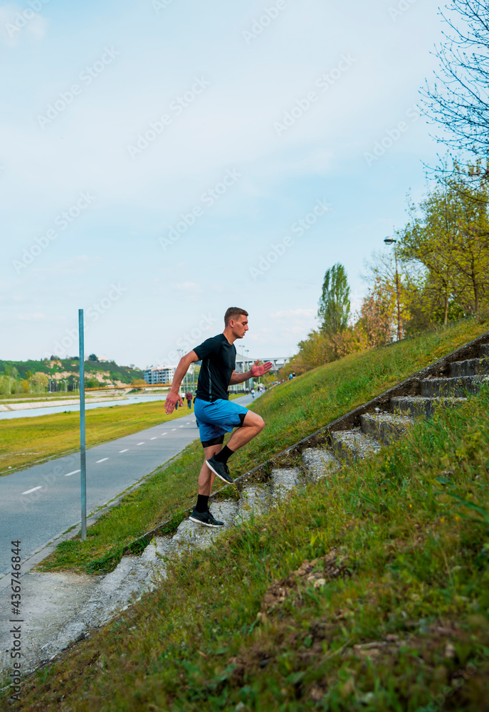Male urban athlete jogger running up stairs