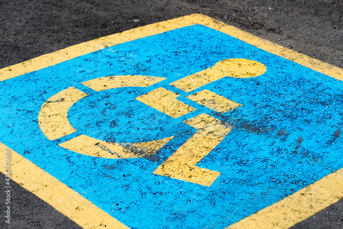 yellow and blue reserved parking sign on the asphalt