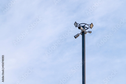 outdoor security camera on a lamppost against a blue sky