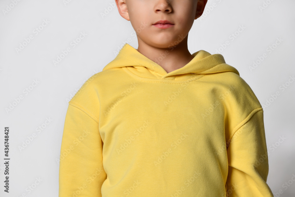 Fototapeta premium Close up detail of a yellow little boy sweatshirt. White background. Details of clothes for boys, sports suit for a student. Children's fashion concept. Place for your text. Banner.