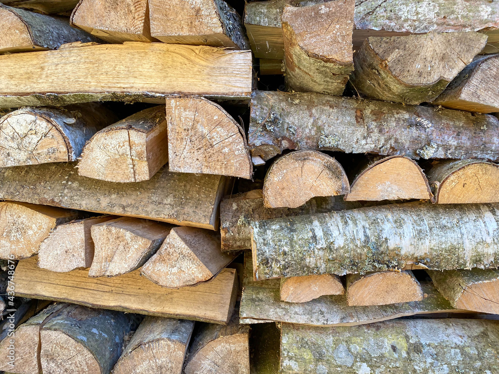 A lot of wooden logs and logs cooked for the winter in a wood-burning stove to light the fireplace and heat the house. The background. Texture A lot of wooden logs and logs cooked for the winter in a wood-burning stove to light the fireplace and heat the house. The background. Texture
