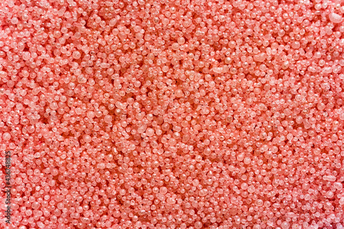 Abstract background with irregular spheres. Pink granules with metallic particles. Macro view.