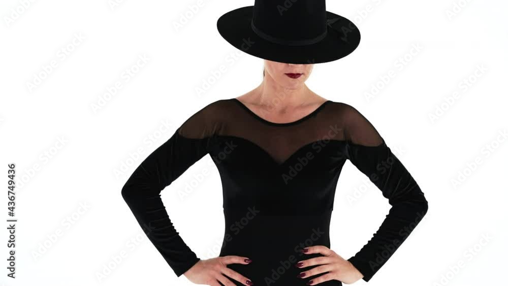 Unrecognizable woman posing with black hat on eyes, white studio background. Femme fatale, stylish outfit of ballet dancer. Unrecognizable woman posing with black hat on eyes, white studio background. Femme fatale, stylish outfit of ballet dancer.