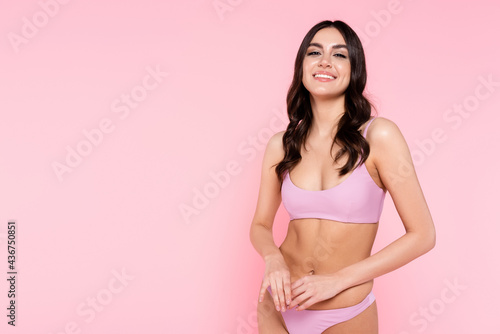 Young brunette woman in swimwear isolated on pink. © LIGHTFIELD STUDIOS
