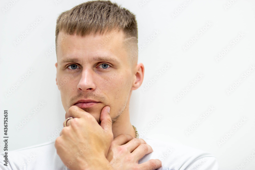 Close-up portrait of a man on a white background, where he holds his hands at the ladder.