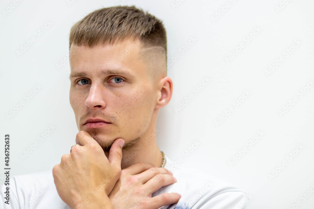 Close-up portrait of a man on a white background, where he holds his hands at the ladder. Close-up portrait of a man on a white background, where he holds his hands at the ladder.