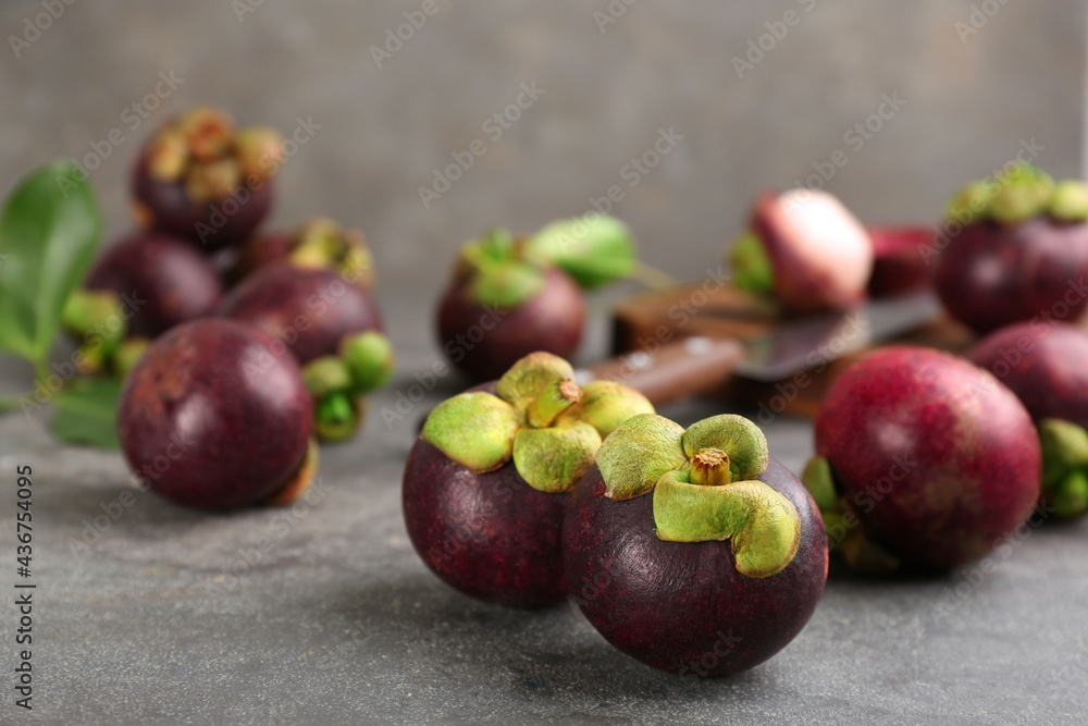 Fresh ripe mangosteen fruits on grey table Fresh ripe mangosteen fruits on grey table