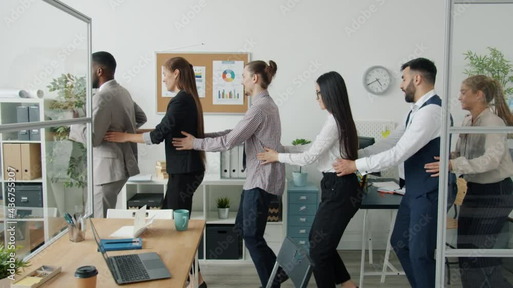 Slow motion of businesspeople multiracial team dancing busy with teambuilding activity in office. Corporate culture and modern lifestyle concept. Slow motion of businesspeople multiracial team dancing busy with teambuilding activity in office. Corporate culture and modern lifestyle concept.