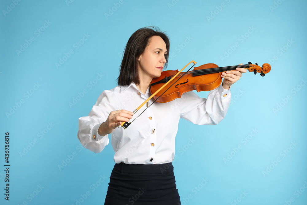 Music teacher playing violin on turquoise background Music teacher playing violin on turquoise background
