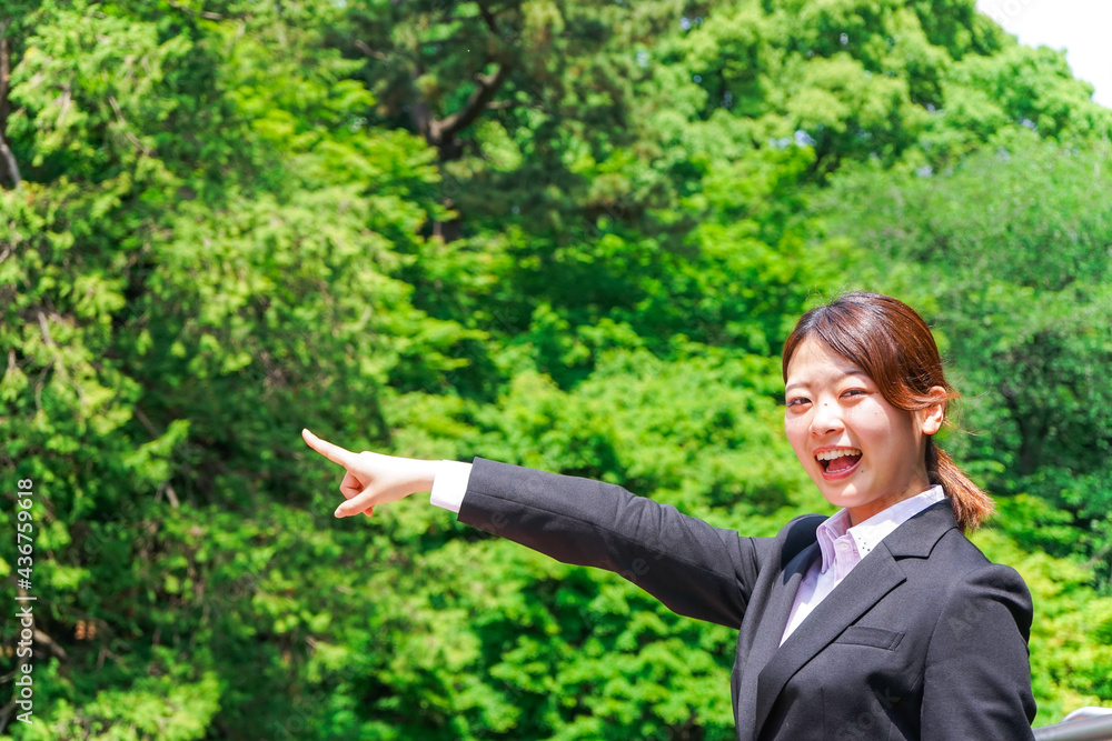 屋外で指をさすビジネスウーマン