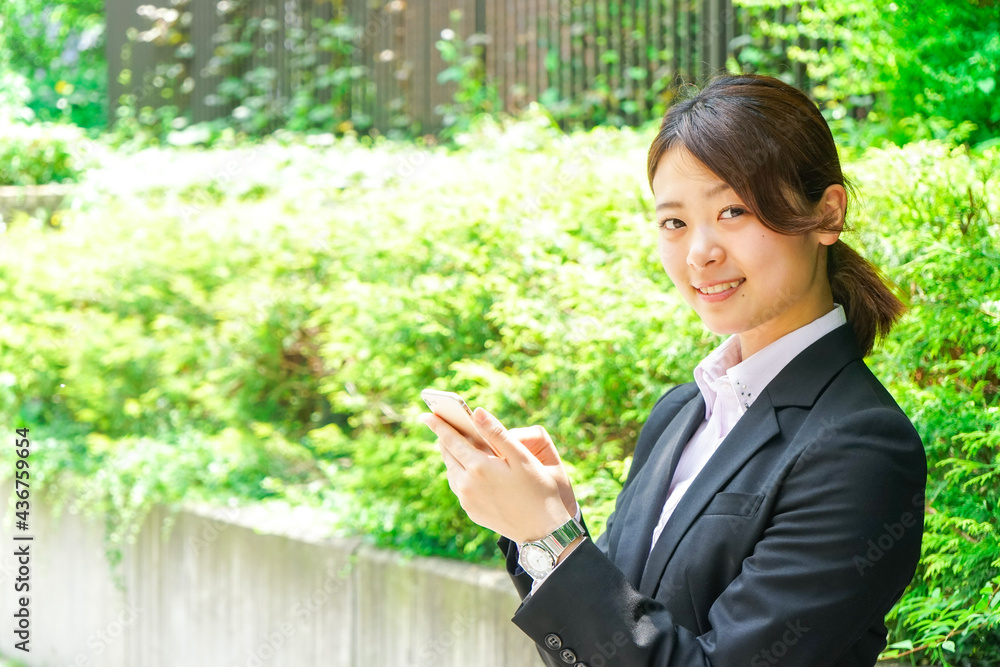 スマホでメッセージを打つビジネスウーマン