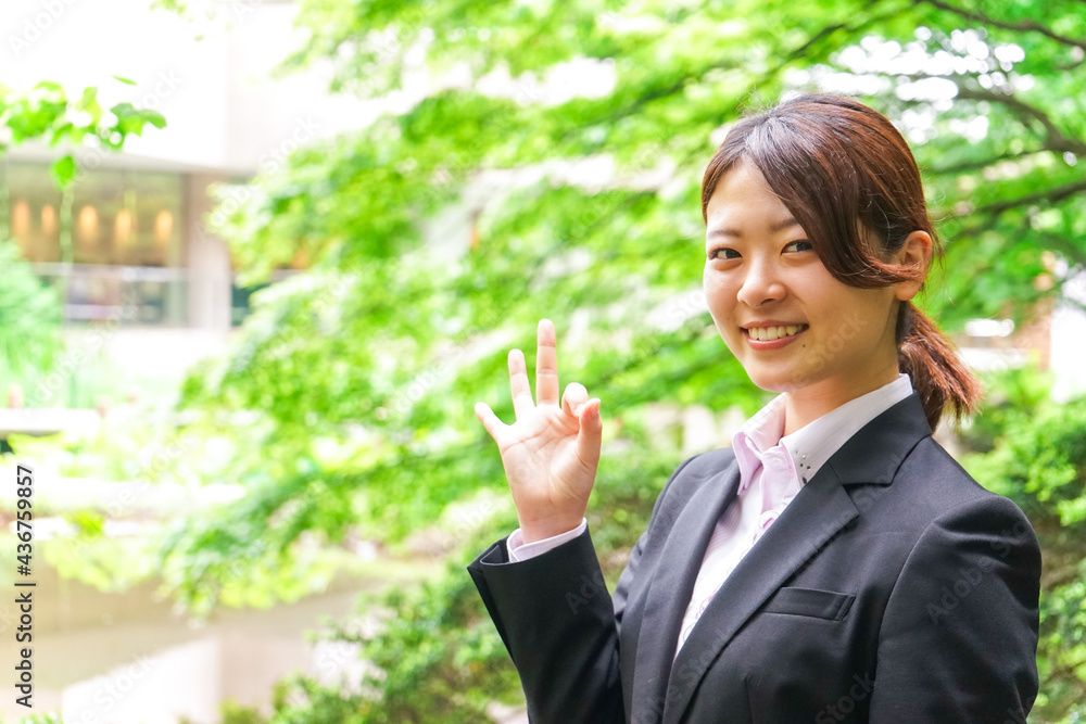グッドサインをする若いビジネスウーマン