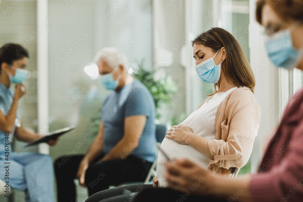 Pregnant Woman With Protective Mask Sitting At The Waiting Room Pregnant Woman With Protective Mask Sitting At The Waiting Room