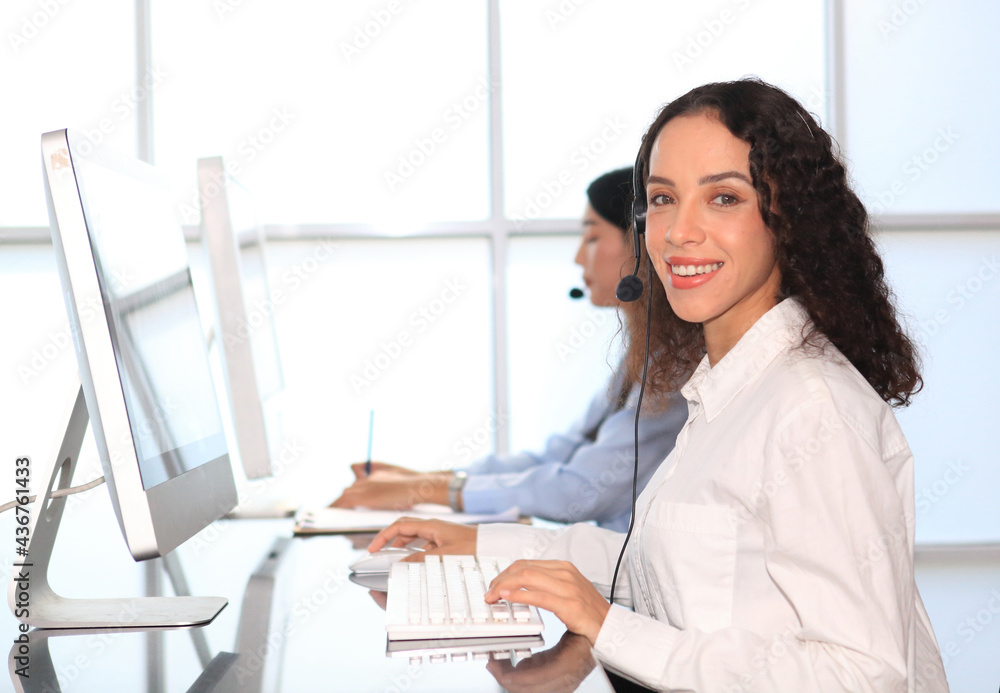 woman agent with headsets working in a call centre,Call center agent with headset working on support hotline in modern office. Call center worker accompanied by her team. woman agent with headsets working in a call centre,Call center agent with headset working on support hotline in modern office. Call center worker accompanied by her team.