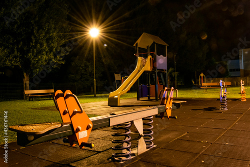 Empty playground or kids park with lights on at night, urban life. © Vtor