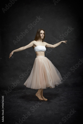 Young girl in white top and peach skirt dancing